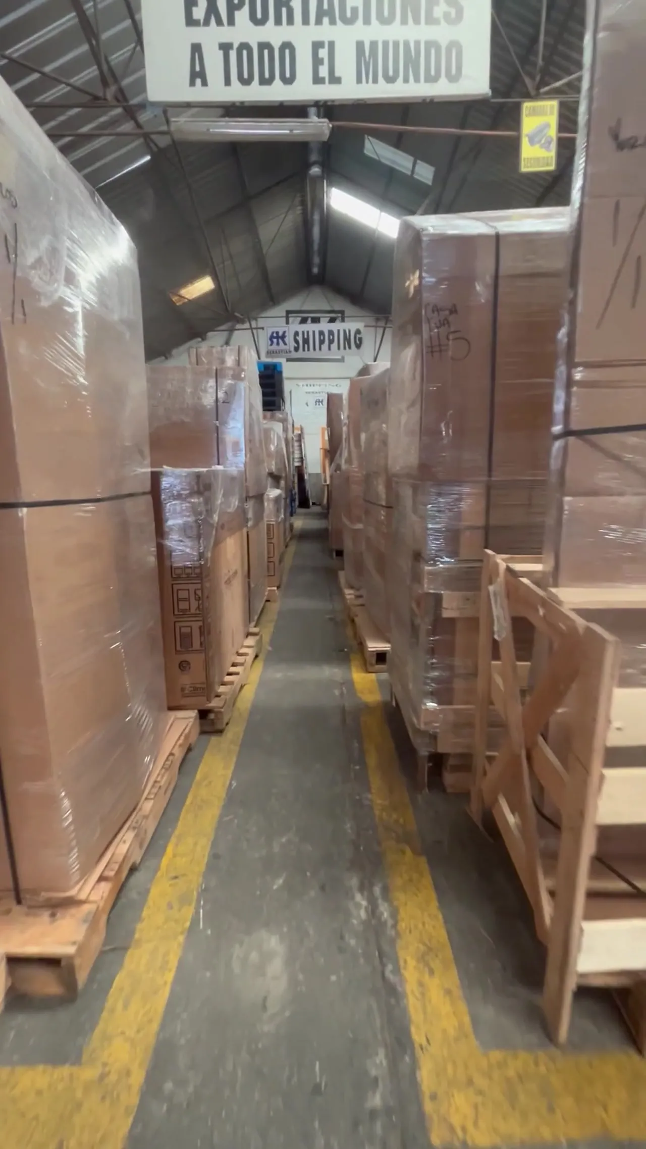 Pasillo de bodega con mercancía embalada y estibada