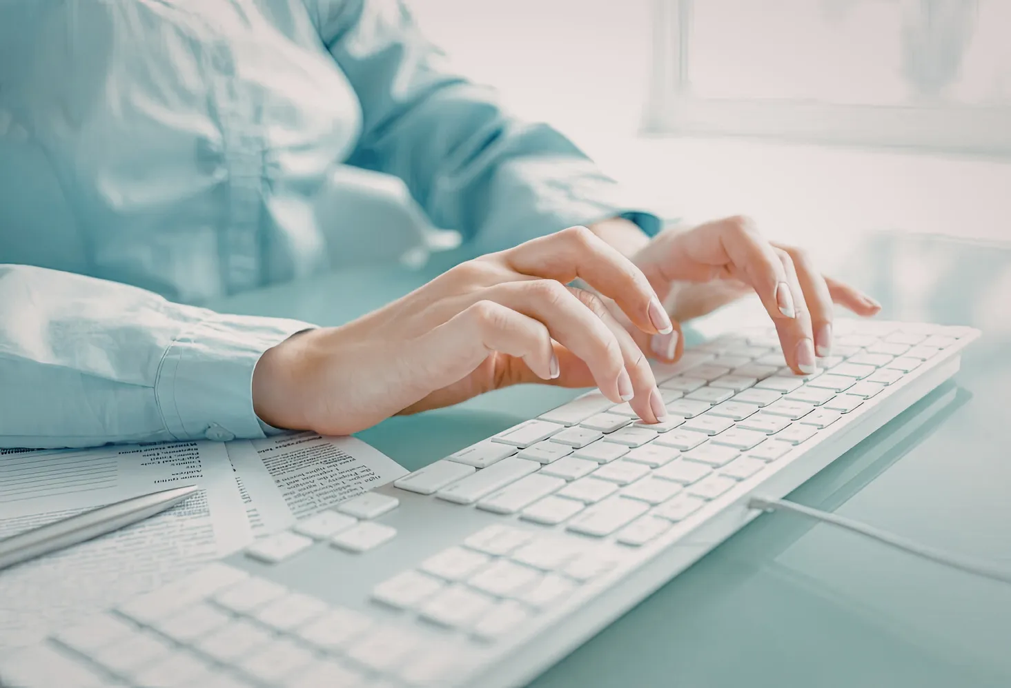 Manos escribiendo en un teclado para actualizar el estatus de la carga