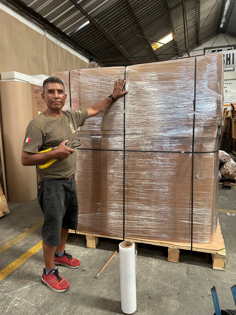 Trabajador de Sebastian Exportaciones flejando una tarima de mercancía en el almacén