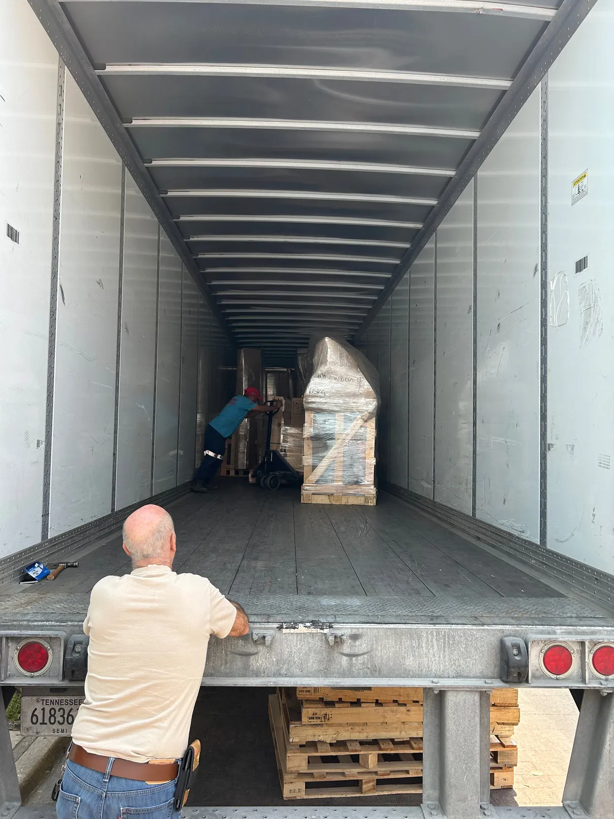 Trabajador acomodando mercancía dentro de la caja de un tráiler